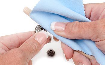 Hands using a polishing cloth on metal
